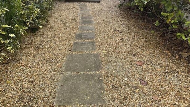 A pathway leading to a house with a white exterior, surrounded by greenery and a gravel driveway. - Private Studio in the Heart of Coral Gables (Miami)