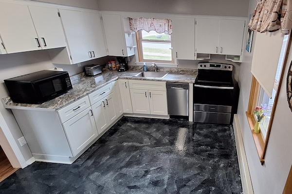 Modern, fully stocked kitchen with stainless steel appliances.
