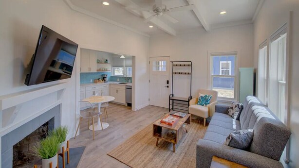 A modern living room with a fireplace, a sofa, a coffee table, and a TV mounted on the wall. - 1Nt. Ok, Walk to Beach and Town, Romantic, Firepit, BBQ (Bungalow2) (Ocean Park)