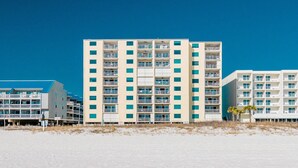Un hôtel à plusieurs étages, doté de balcons, situé près d’une plage.