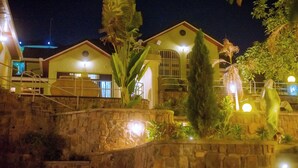 Un hotel con diversi edifici, pareti in pietra e illuminazione esterna.