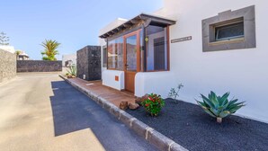 Un edificio moderno con fachada de piedra, puerta de madera y un ventanal pequeño.