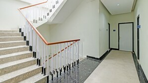 A modern hotel interior with a marble staircase, white walls, and a clean, minimalist design. - Collection O 90774 Homi Stay (Surakarta)