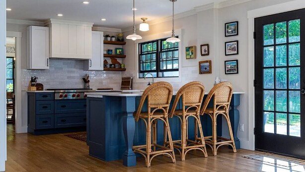 A kitchen with a large island, white cabinets, and wicker chairs. - Remodeled Beautiful 4-Bedroom Secluded Home in Downtown Bar Harbor! (Bar Harbor)