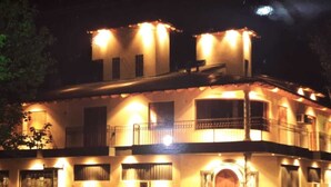 A two-story building with multiple balconies and a central entrance.