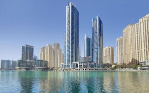 A city skyline with high-rise buildings, a waterfront, and a clear sky. - Stunning Marina View 1 bedroom (Dubai)