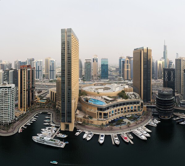 A high-rise hotel with a pool, surrounded by a marina with boats. - Stunning Marina View 1 bedroom (Dubai)