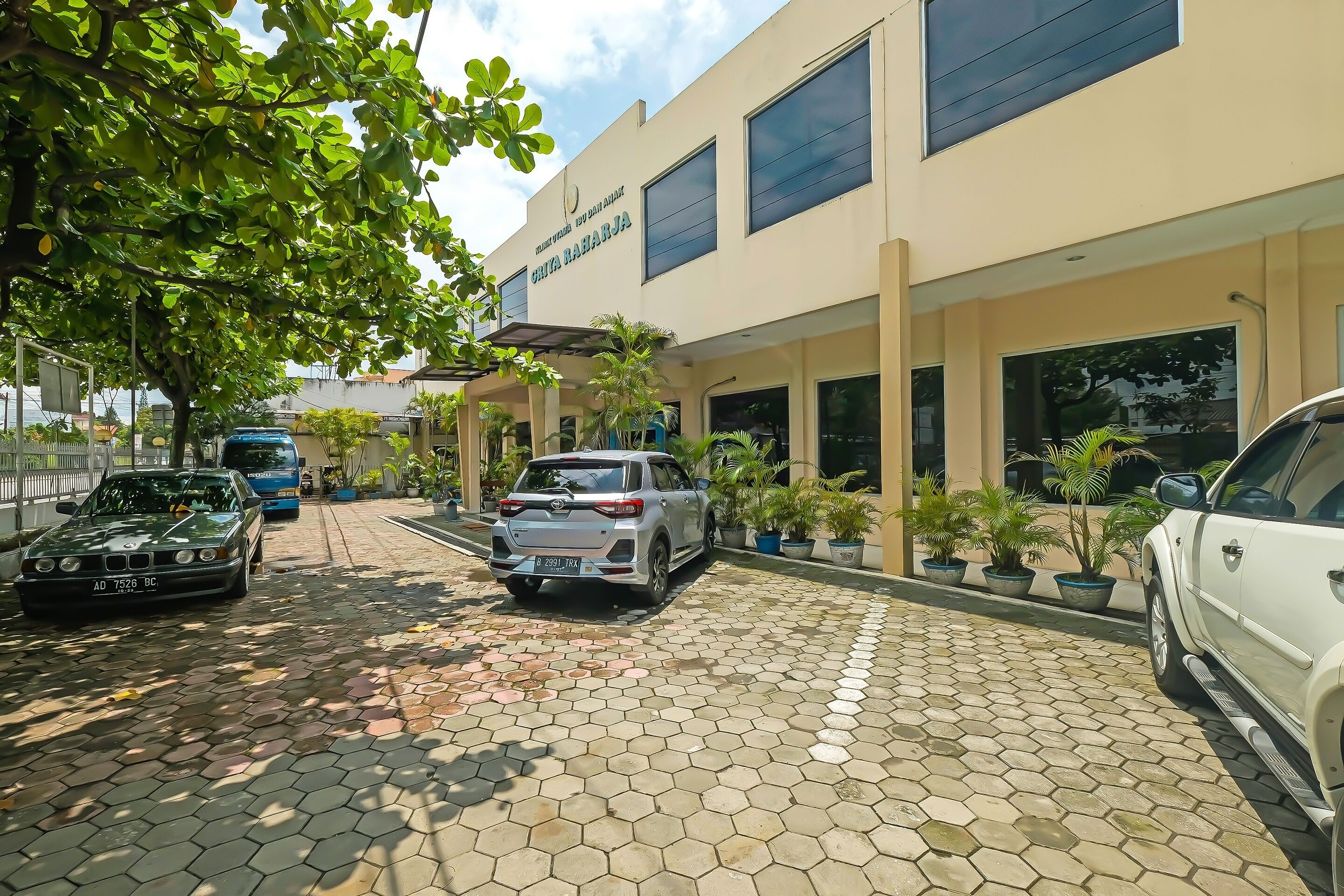 A building with a sign reading "CHITA BARARJA" and a parking area with several cars.