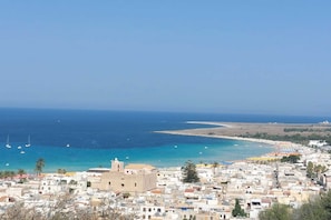 Un pueblo costero con edificios, una playa y barcos.