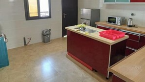 Een kleine keuken met een spoelbak, een magnetron en een koelkast.
