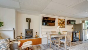 A cozy living room with a fireplace, a dining area, and a kitchen with modern appliances.