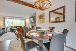 Een eetgedeelte met een ronde tafel voor zes personen, omringd door zes stoelen.