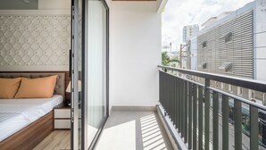 A bedroom with a bed, a nightstand, and a sliding glass door leading to a balcony.