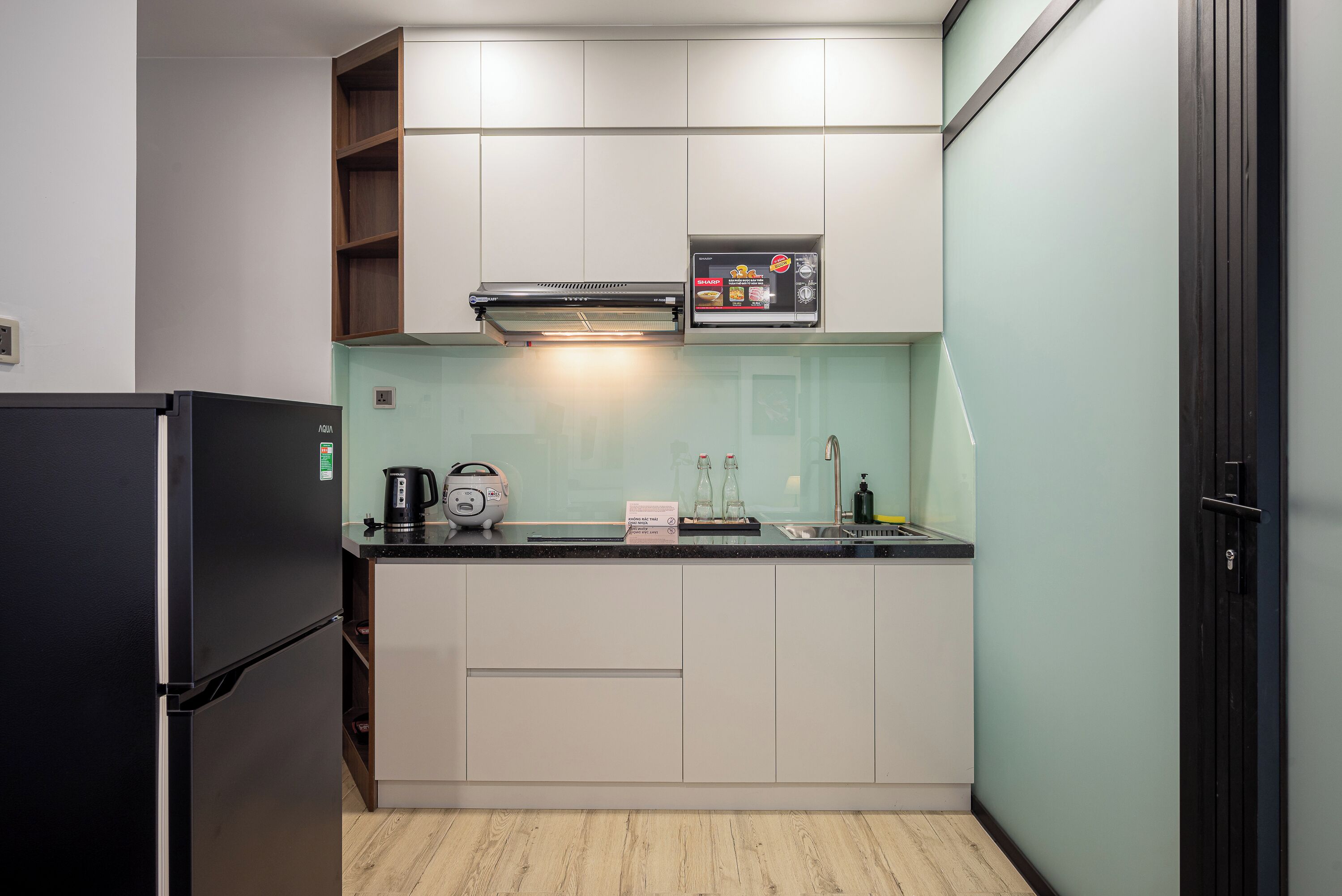 A compact kitchen with a built-in oven, a coffee maker, and a microwave.