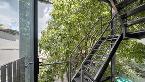 A metal staircase with a handrail leading to an outdoor area with trees.