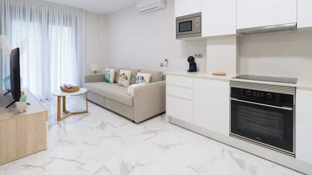 A modern living room with a sofa, a television, and a small table.
