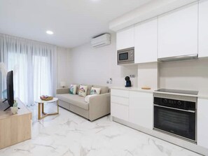 A modern living room with a sofa, a television, and a small table.