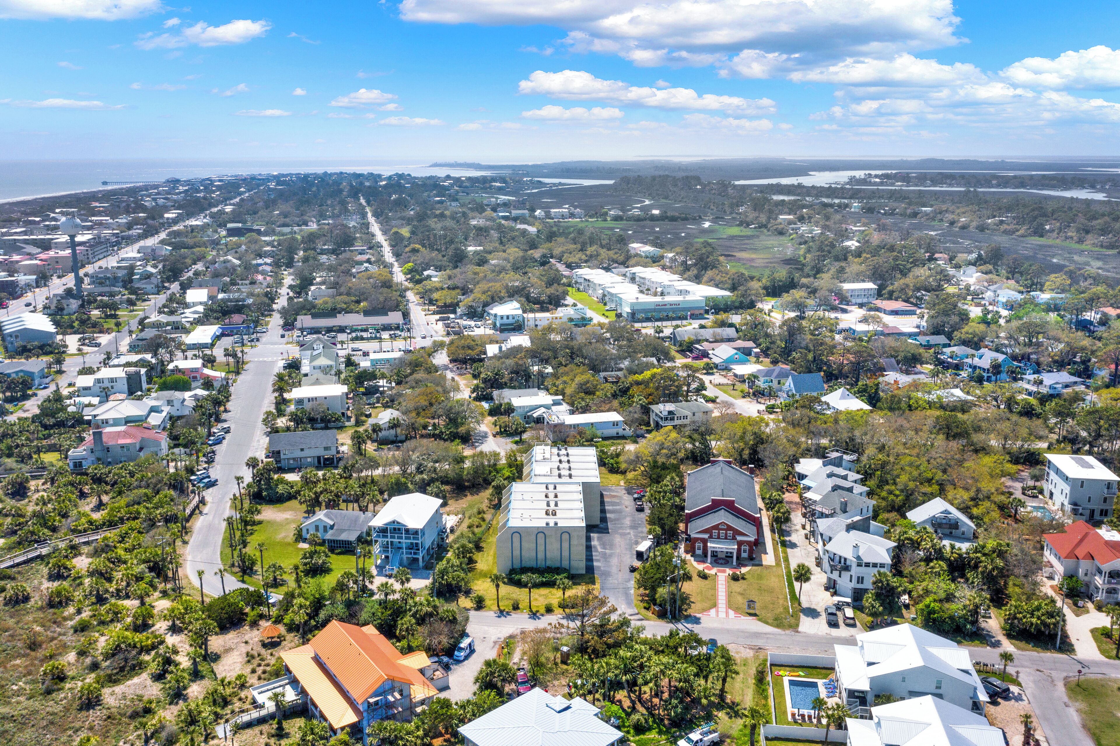 An aerial view of a residential area with houses, roads, and a large building with a flat roof.