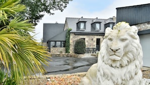 A stone building with a grey roof, a stone facade, and a paved driveway. - Chez Marie-Céline - Maison avec jacuzzi à 20 min du Val André (Plestan)