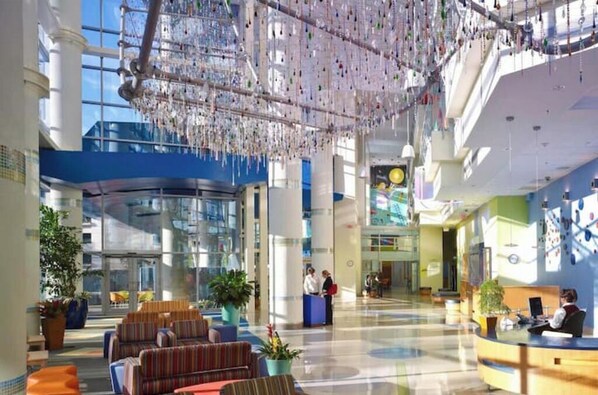 Relax in our spacious lobby with a seating area, reception desk, and unique chandelier.