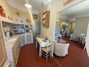 Relax in this open-plan living space with a kitchen and seating area, perfect for conversation and relaxation.