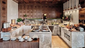 A modern kitchen with a central island, marble countertops, and wooden paneling on the walls. - Crowne Plaza TASHKENT by IHG (Tashkent)