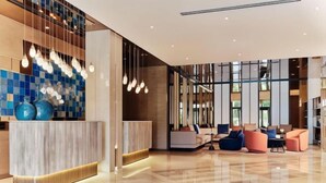A modern lobby with a reception desk, seating area, and large windows. - Crowne Plaza TASHKENT by IHG (Tashkent)