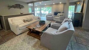 A spacious living room with a white sofa, grey armchairs, and a wooden coffee table. - House on Smith Lake! No steps to water/dock! 4 bedrooms & 3 full baths. (Jasper)