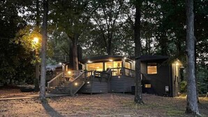 A cabin with a wooden deck and stairs leading to the entrance. - House on Smith Lake! No steps to water/dock! 4 bedrooms & 3 full baths. (Jasper)