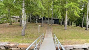 A concrete bridge with metal railings over a body of water, surrounded by trees and a building in the background. - House on Smith Lake! No steps to water/dock! 4 bedrooms & 3 full baths. (Jasper)