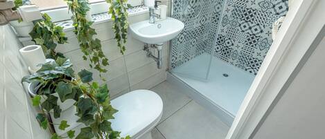 Une salle de bain équipée de toilettes, d’un lavabo et d’une douche.