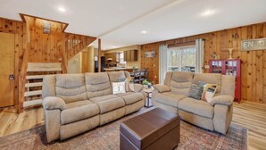 A cozy living room with a sofa set, a coffee table, and a staircase leading to a dining area. - “Bearly-Be-Haven” w/hot tub, firepit, Bearly-Be-Haven (Basye)