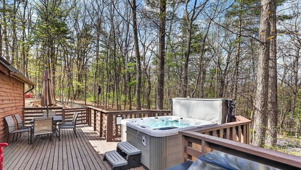 A wooden deck with a hot tub, grill, and outdoor seating area surrounded by trees. - “Bearly-Be-Haven” w/hot tub, firepit, Bearly-Be-Haven (Basye)