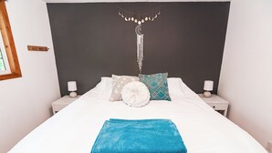 A neatly made bed with white bedding, a teal throw blanket, and decorative pillows. - Perfect Waterfront Getaway between the Lakes  (Montello)