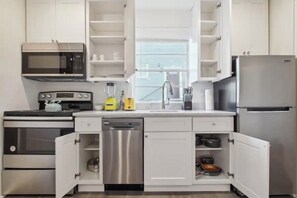 Enjoy cooking in this well-equipped kitchen with a sink, stainless steel appliances, and ample storage.