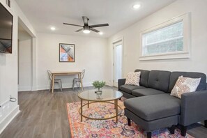 Relax in this stylish living room with a comfortable sofa, coffee table, and vibrant rug.