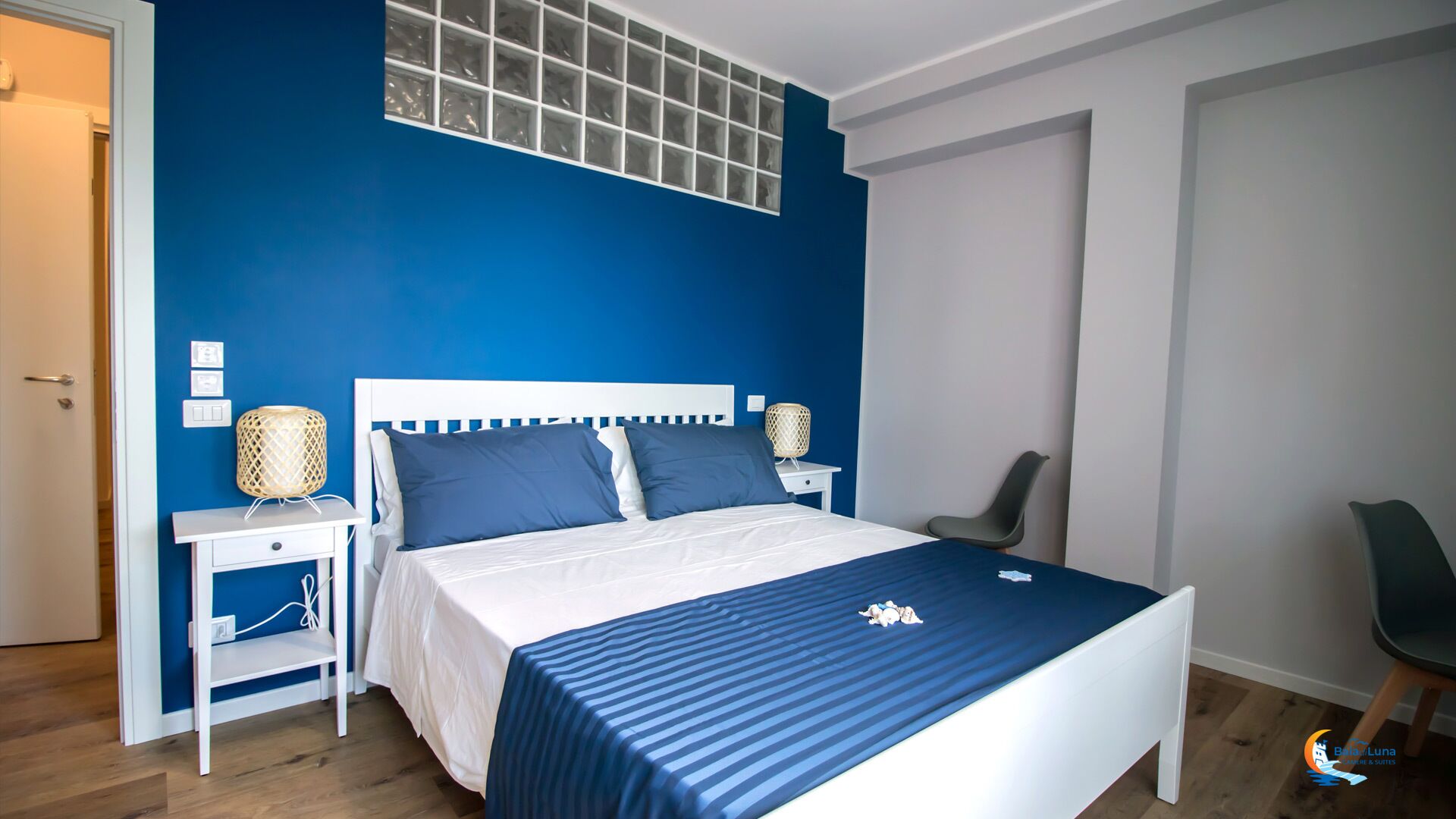 A bedroom with a bed, bedside tables, a chair, and a window.