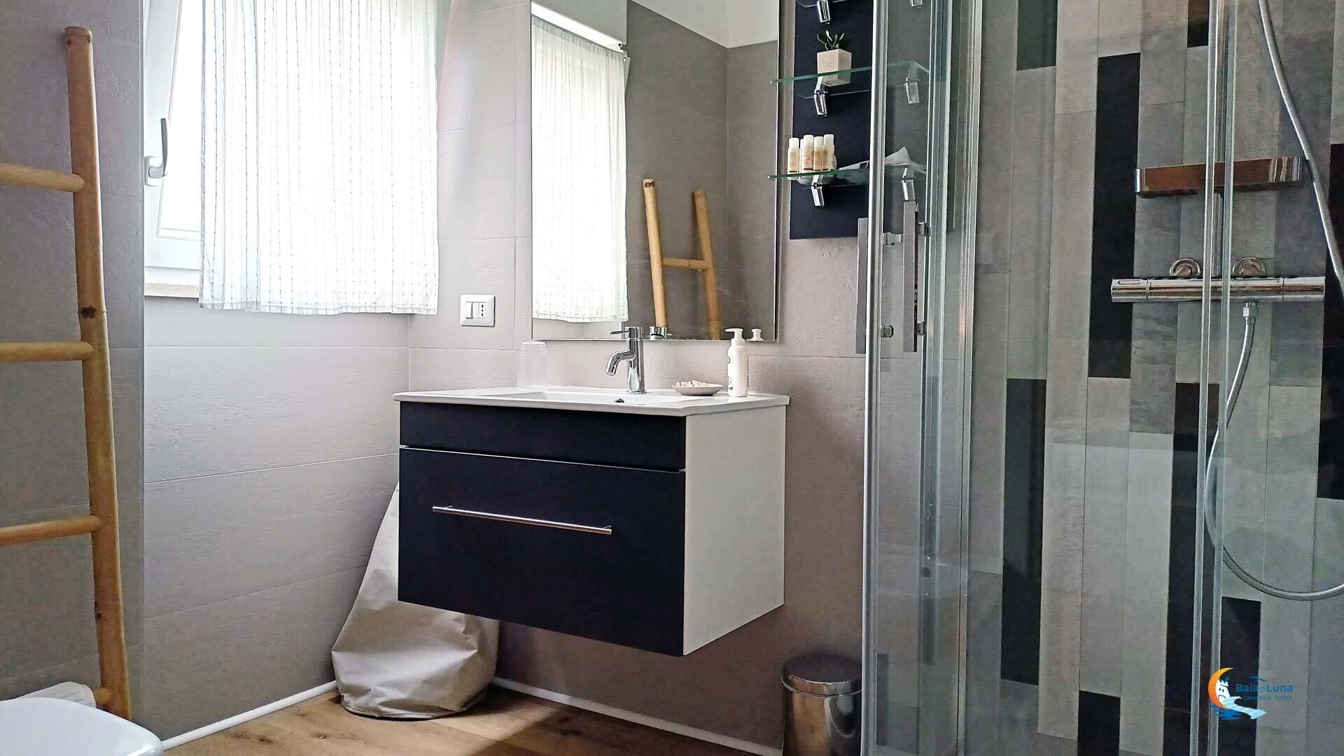 Une salle de bain au design moderne, comprenant un lavabo, un miroir et une douche.