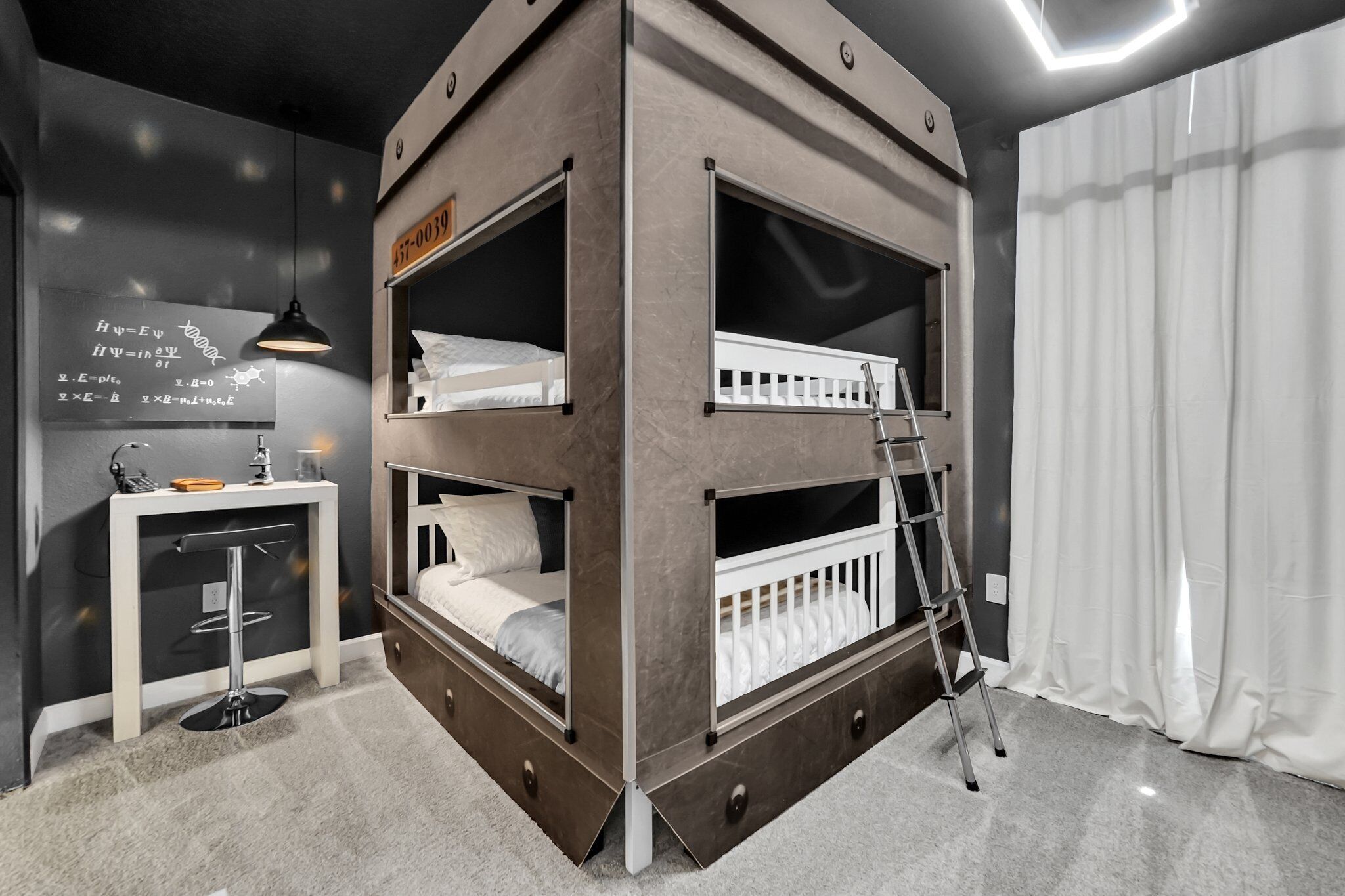 Een slaapkamer met een stapelbed, bureau en een ladder, een wit gordijn en een prikbord met vergelijkingen.