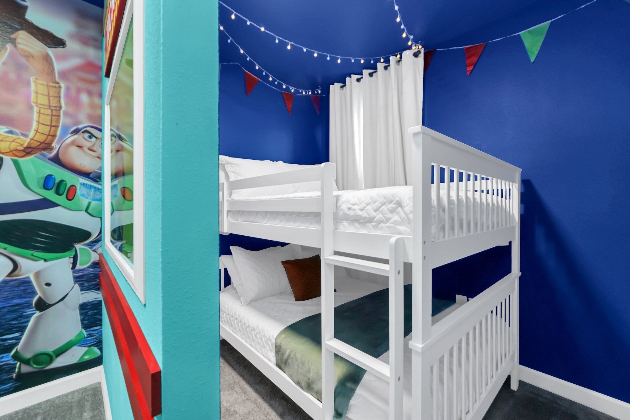 A bunk bed room with a blue wall, white bedding, and a string of lights.