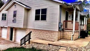 A single-story house with a front porch, a garage, and a brick foundation. - Seascape Townhome #69- Sunset Vacation Rentals (Geneva)