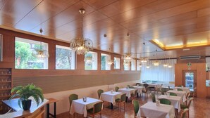 A restaurant with wooden paneling, large windows, and hanging chandeliers. Tables are arranged for dining. - Camelia Rooms Venice Guesthouse near Mestre Train Station - 24 rooms (Venezia)