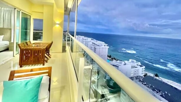 Uma varanda com vista para o mar e para a paisagem urbana.