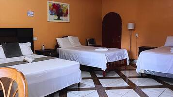 A hotel room with two beds, a wooden chair, a painting on the wall, and an air conditioning unit.