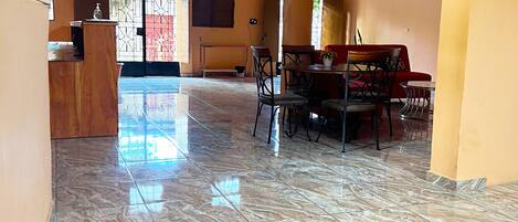 A spacious lobby with a marble floor, a reception desk, and a seating area with a piano.