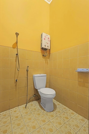 Un baño con paredes amarillas, un inodoro blanco y una ducha.