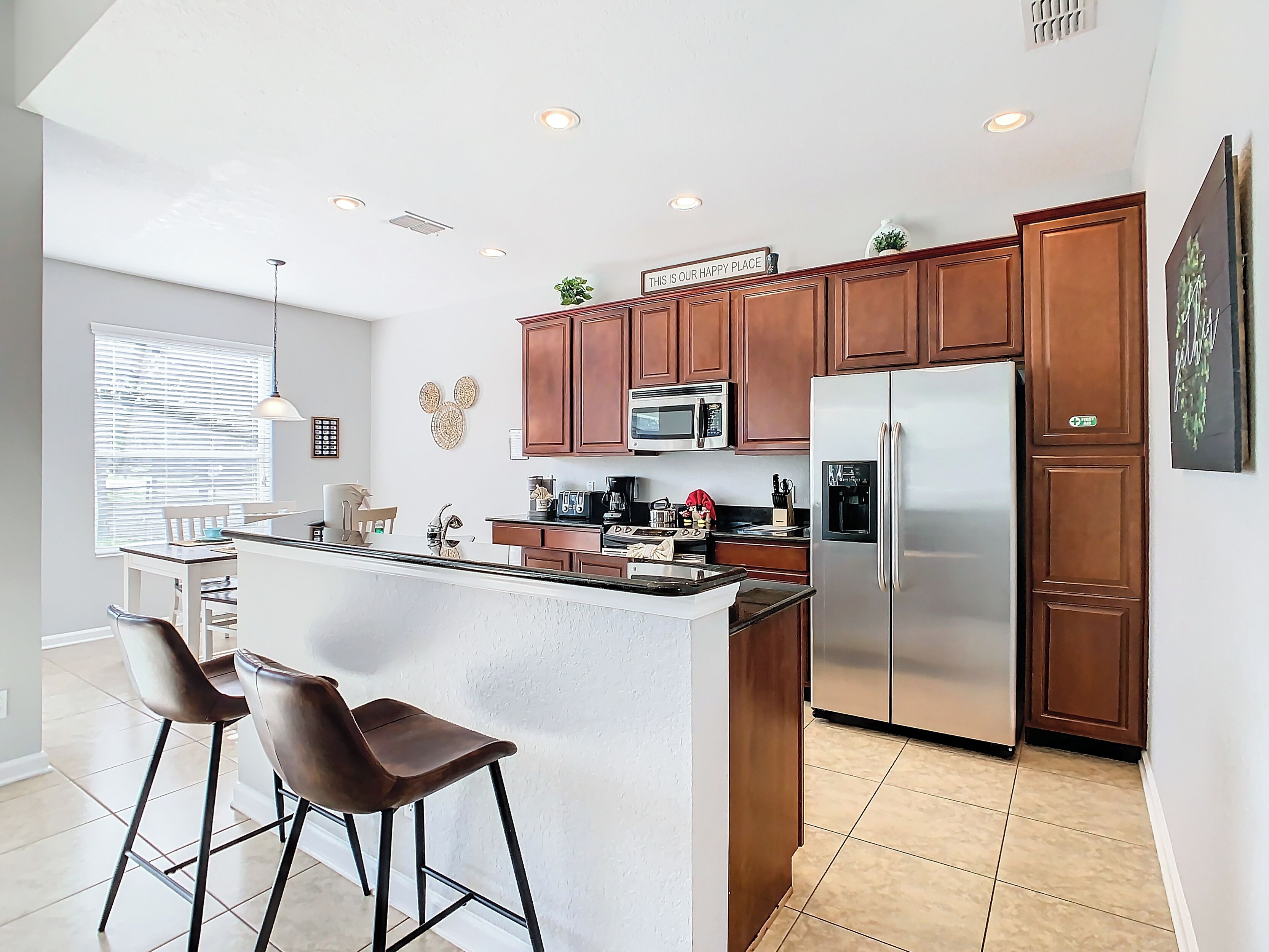 A modern kitchen with a central island, stainless steel appliances, and wooden cabinetry.