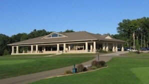 A large, single-story building with a flat roof and a covered porch area.