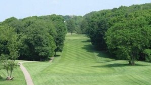 Un parcours de golf doté d’allées bien entretenues, d’arbres et d’un sentier pédestre.