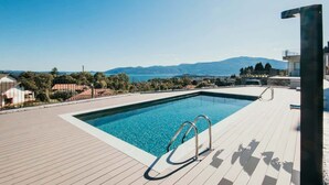Une piscine offrant une vue dégagée sur le paysage environnant et les montagnes en arrière-plan.